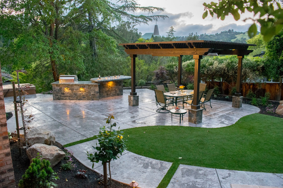 Mid-sized mediterranean backyard patio in San Francisco with stamped concrete, a pergola and an outdoor kitchen.