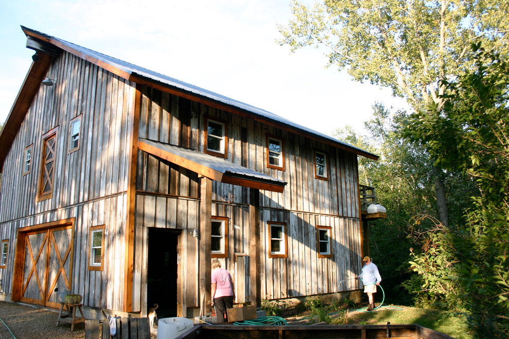 Large mountain style brown two-story wood gable roof photo with a metal roof