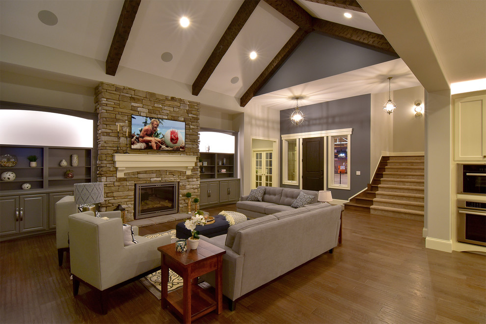 Design ideas for a large arts and crafts formal open concept living room in Cleveland with grey walls, a standard fireplace, a stone fireplace surround and a wall-mounted tv.