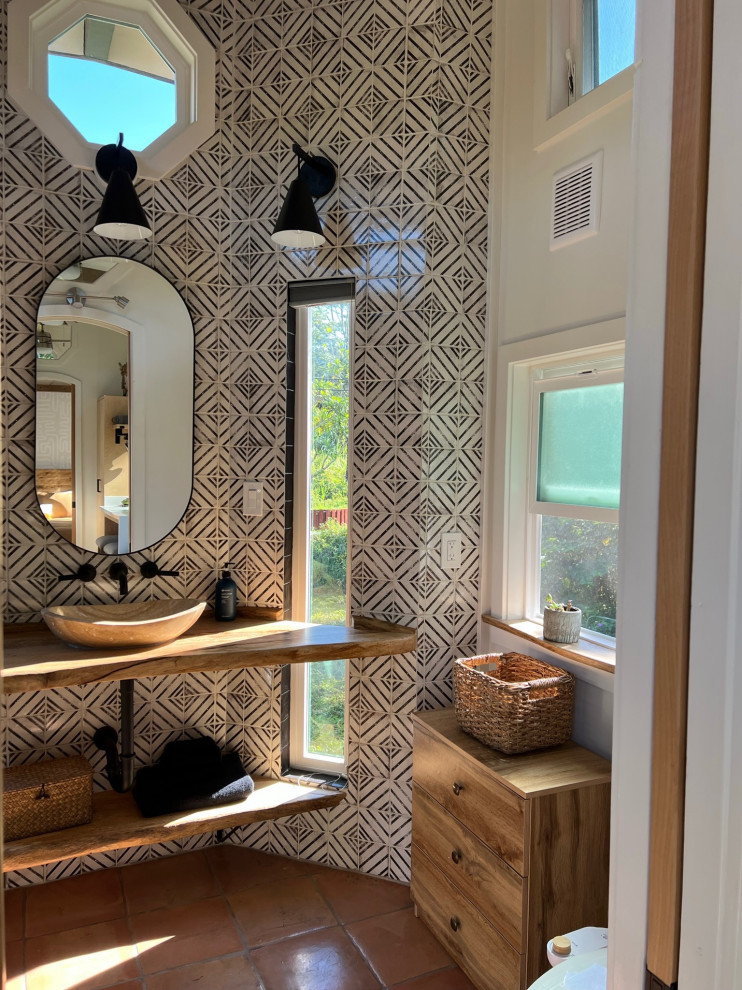 Photo of a mid-sized country master bathroom in Hawaii with open cabinets, beige cabinets, a corner shower, a bidet, black and white tile, ceramic tile, white walls, terra-cotta floors, a vessel sink, wood benchtops, orange floor, a shower curtain, beige benchtops, a niche, a single vanity, a floating vanity, exposed beam and wood walls.