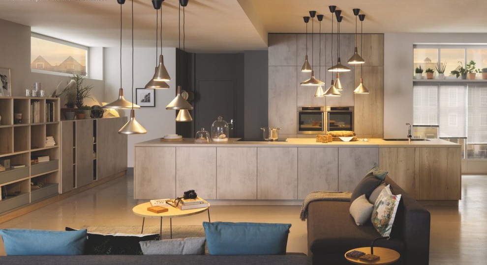 Contemporary galley open plan kitchen in London with flat-panel cabinets, beige cabinets, with island, beige floor and beige benchtop.