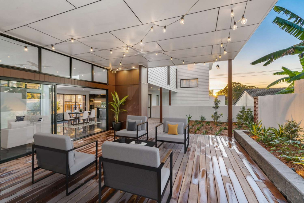 Photo of a large contemporary side yard deck in Gold Coast - Tweed with with privacy feature and a roof extension.