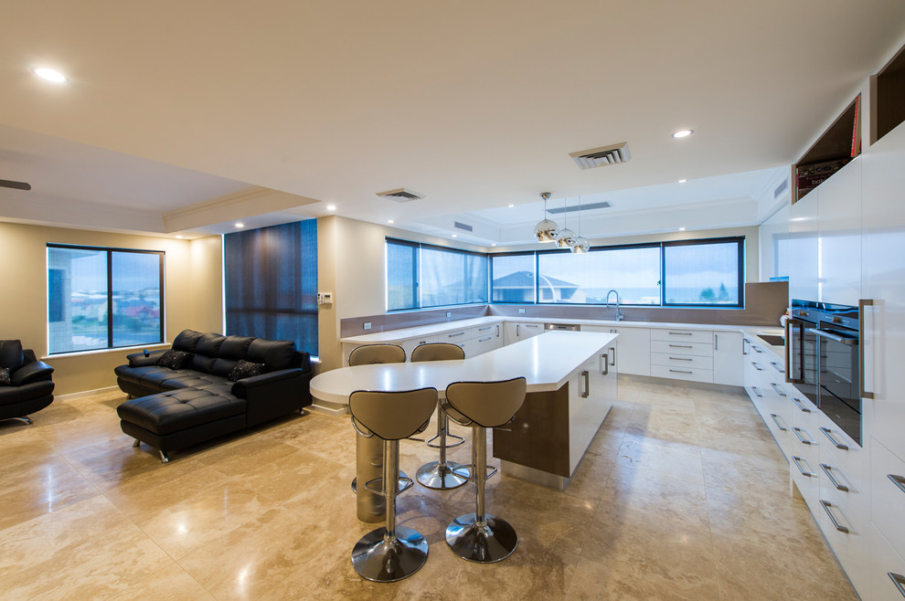 Design ideas for a large contemporary u-shaped open plan kitchen in Perth with an integrated sink, flat-panel cabinets, white cabinets, solid surface benchtops, multi-coloured splashback, glass sheet splashback, black appliances, porcelain floors and with island.
