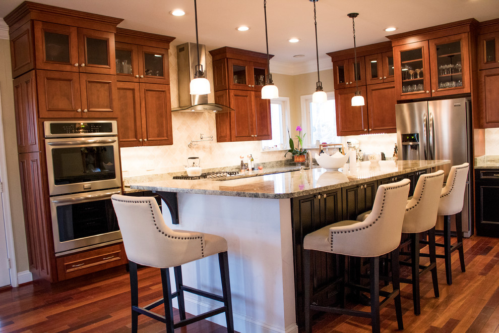 Large transitional l-shaped dark wood floor and brown floor enclosed kitchen photo in DC Metro with raised-panel cabinets, dark wood cabinets, an island, a double-bowl sink, stainless steel appliances, granite countertops, beige backsplash and limestone backsplash