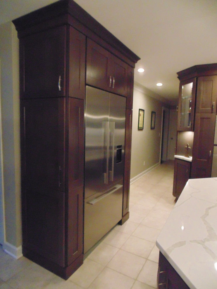 Eat-in kitchen - mid-sized transitional u-shaped ceramic tile and beige floor eat-in kitchen idea with an undermount sink, recessed-panel cabinets, dark wood cabinets, quartz countertops, white backsplash, stone slab backsplash, stainless steel appliances, an island and white countertops