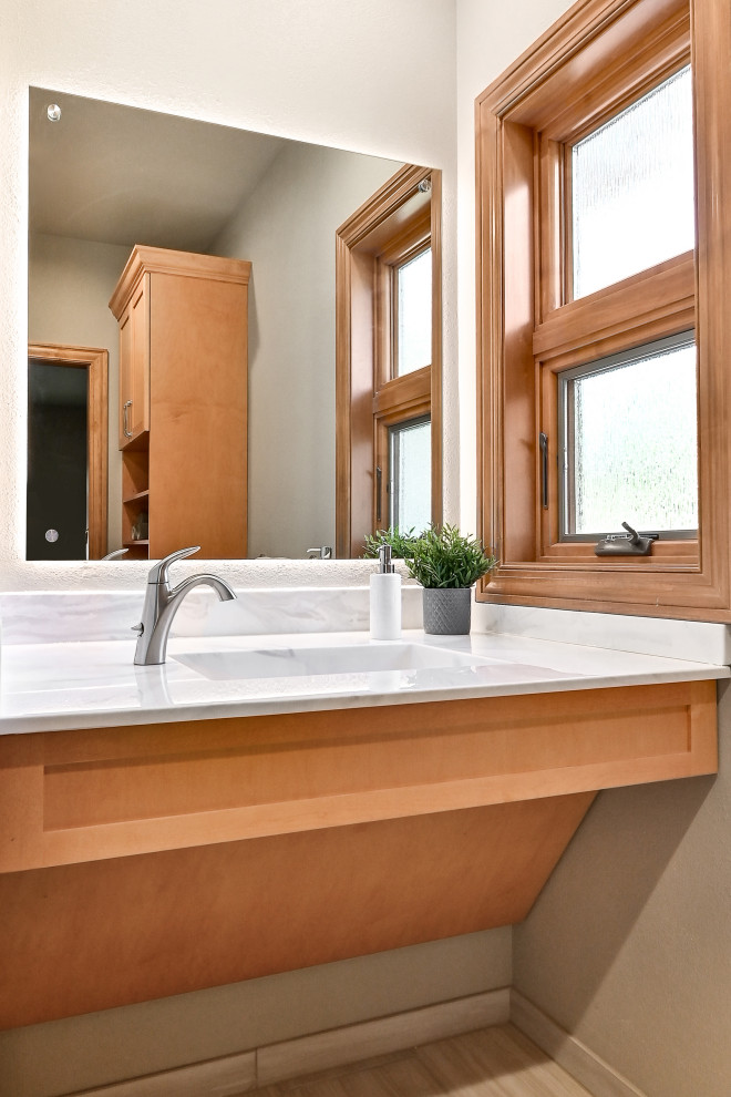 This is an example of a mid-sized traditional master bathroom in Milwaukee with open cabinets, light wood cabinets, an open shower, a bidet, beige tile, porcelain tile, beige walls, porcelain floors, an integrated sink, solid surface benchtops, beige floor, a shower curtain, white benchtops, a niche, a single vanity and a floating vanity.