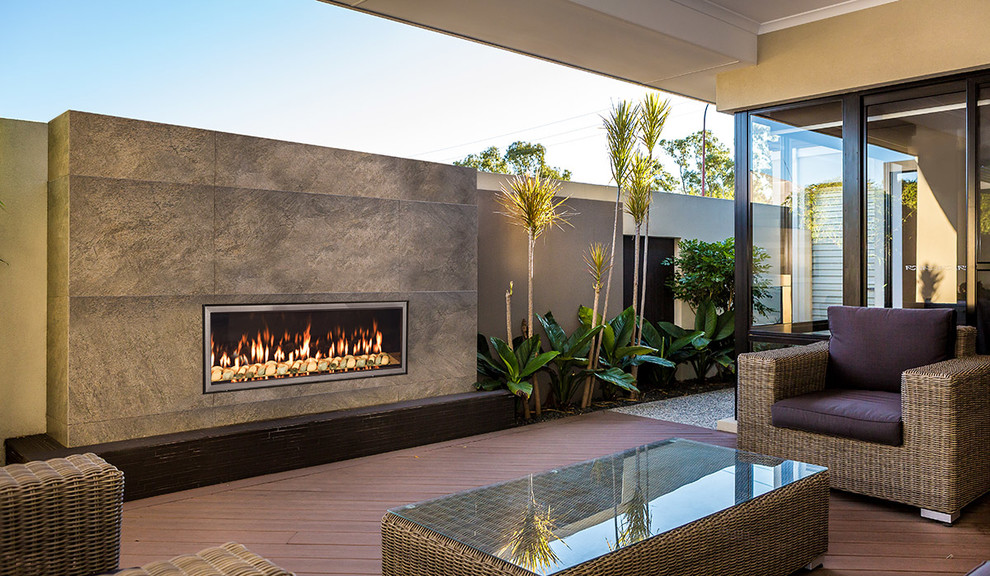 Mid-sized contemporary backyard patio in Other with a fire feature, decking and a roof extension.