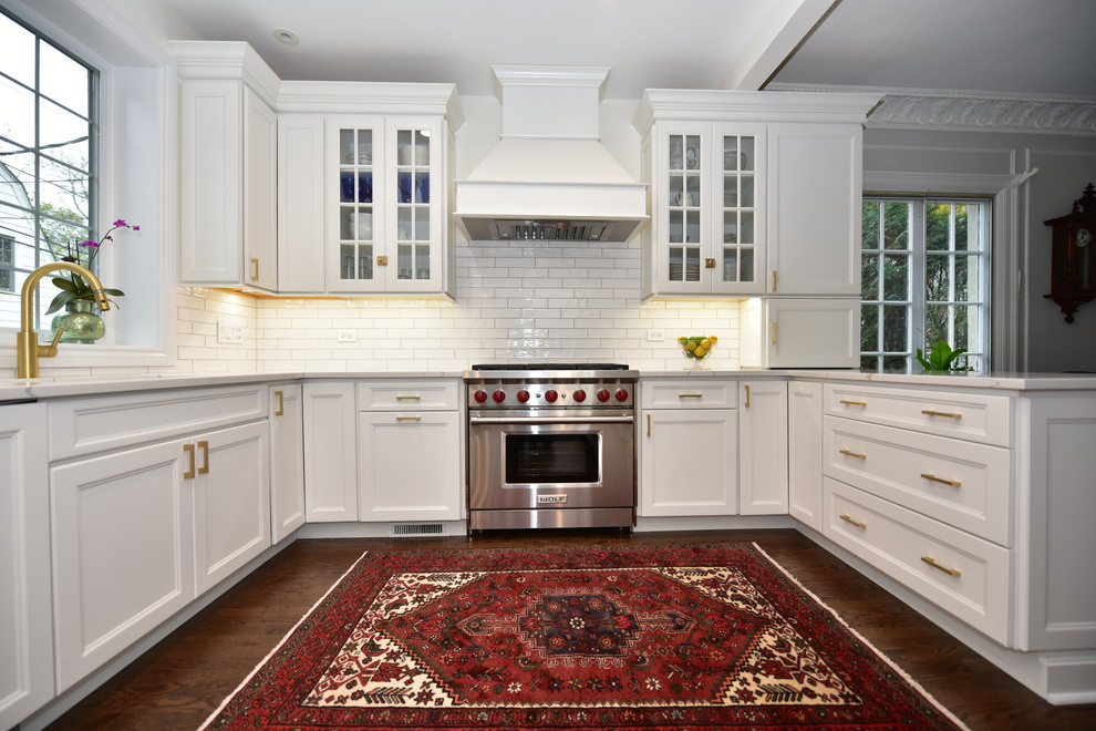 Kitchen - transitional u-shaped dark wood floor and brown floor kitchen idea in Chicago with an undermount sink, recessed-panel cabinets, white cabinets, white backsplash, subway tile backsplash, stainless steel appliances and beige countertops