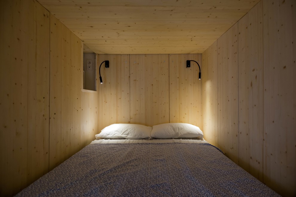 Ejemplo de dormitorio tipo loft pequeño con paredes blancas y suelo laminado
