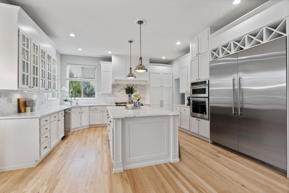 Design ideas for a large transitional kitchen in Denver with shaker cabinets, white cabinets, white splashback, with island and white benchtop.