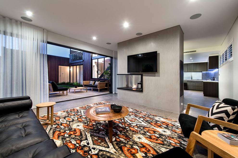 This is an example of a contemporary living room in Perth with a two-sided fireplace.