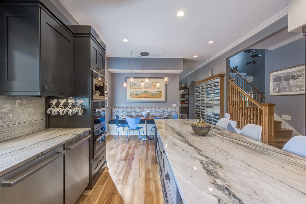 Eat-in kitchen - large transitional u-shaped light wood floor eat-in kitchen idea in Denver with a farmhouse sink, recessed-panel cabinets, gray cabinets, quartzite countertops, blue backsplash, ceramic backsplash, stainless steel appliances and an island