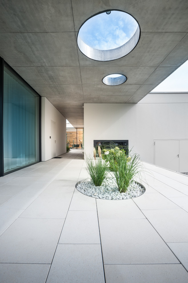 Inspiration for a large modern backyard deck in Berlin with a roof extension.