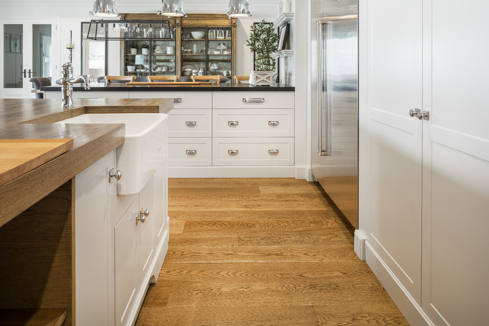 Inspiration for a large country kitchen in Perth with a farmhouse sink, shaker cabinets, grey cabinets, brown splashback, stainless steel appliances, medium hardwood floors, with island, wood benchtops and brown benchtop.