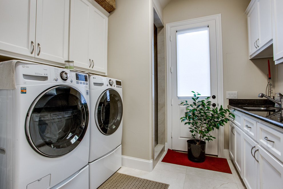 Design ideas for a traditional laundry room in Dallas with white cabinets.