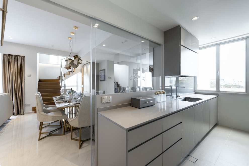 This is an example of a contemporary kitchen in Singapore with an undermount sink, flat-panel cabinets, grey cabinets and grey floor.
