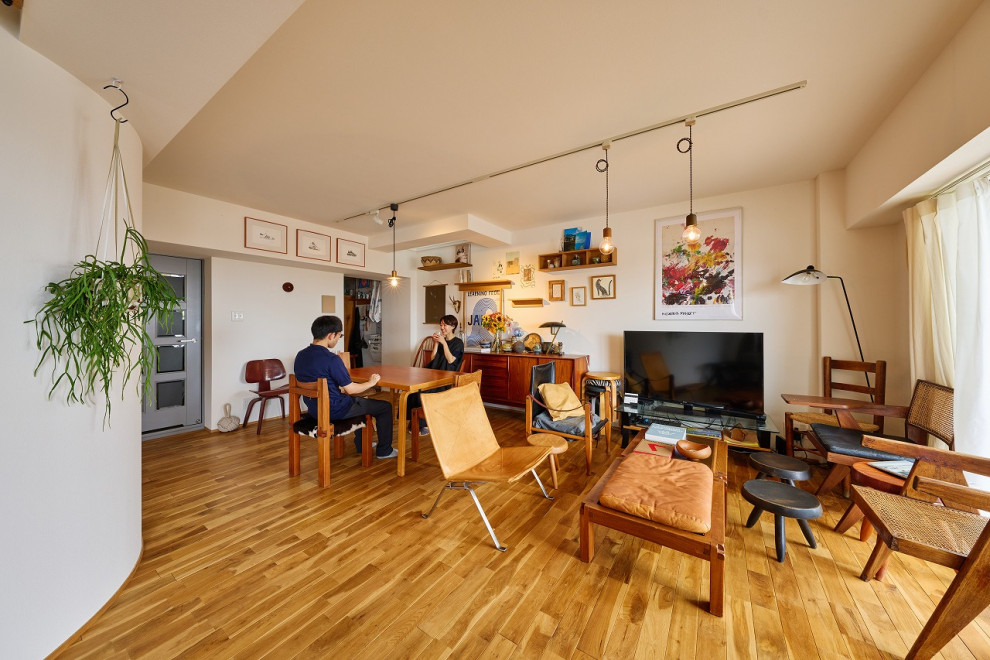 Cette image montre un salon nordique avec un sol en bois brun.