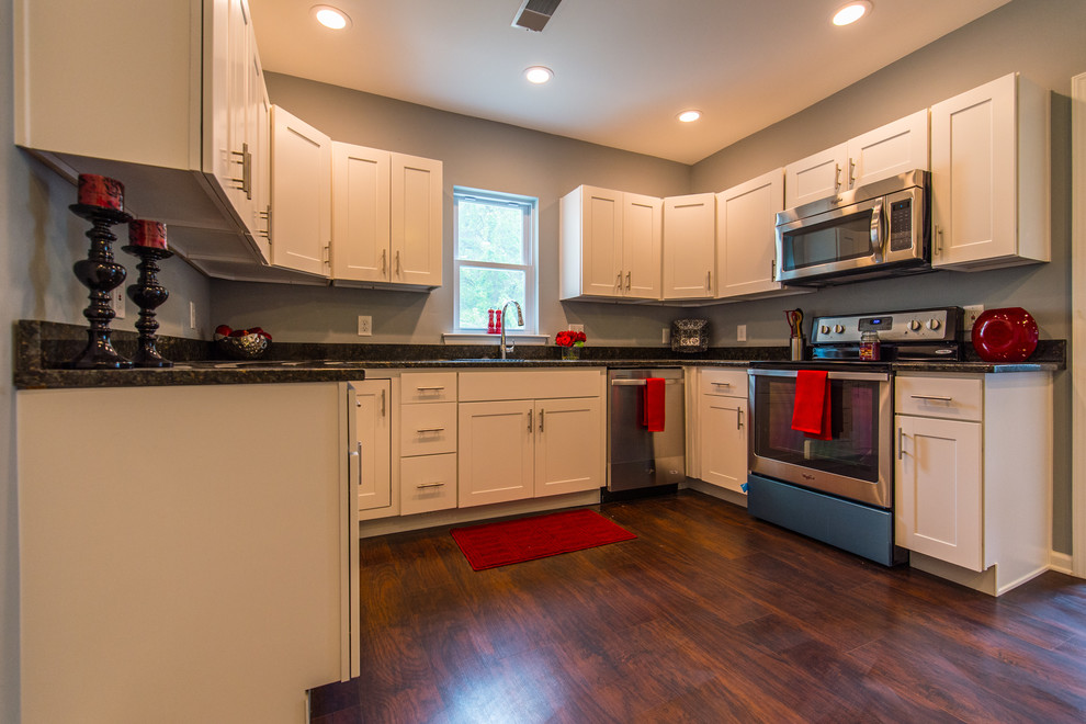Photo of a mid-sized transitional u-shaped separate kitchen in Philadelphia with an undermount sink, shaker cabinets, white cabinets, granite benchtops, stainless steel appliances and dark hardwood floors.
