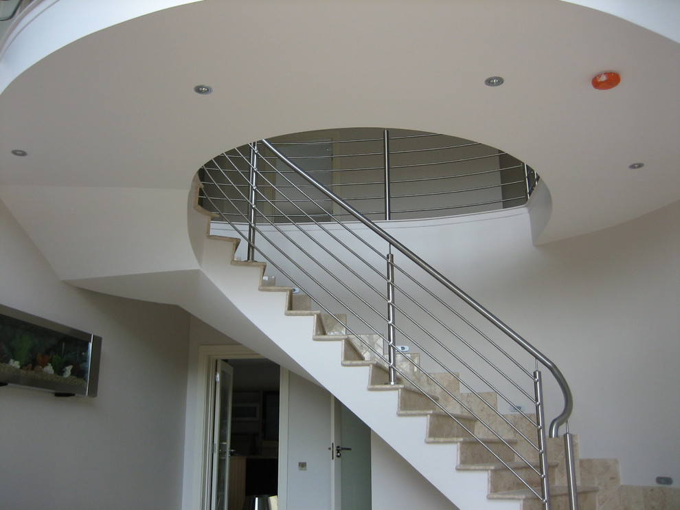 This is an example of a contemporary concrete curved staircase in Other with concrete risers.