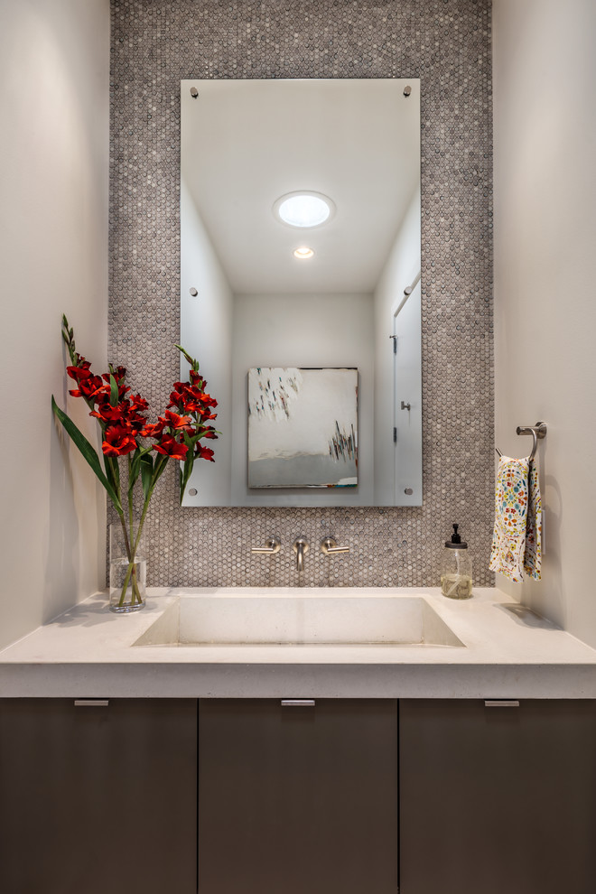 Inspiration for a small contemporary powder room in Charleston with flat-panel cabinets, dark wood cabinets, gray tile, mosaic tile, white walls, an integrated sink and concrete benchtops.