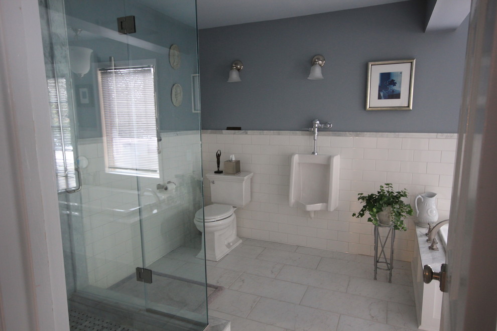 Cette photo montre une grande salle de bain principale en bois vieilli avec une baignoire posée, un urinoir, un carrelage blanc, un mur gris, un sol en marbre, un lavabo encastré, un plan de toilette en marbre, un plan de toilette blanc et meuble double vasque.
