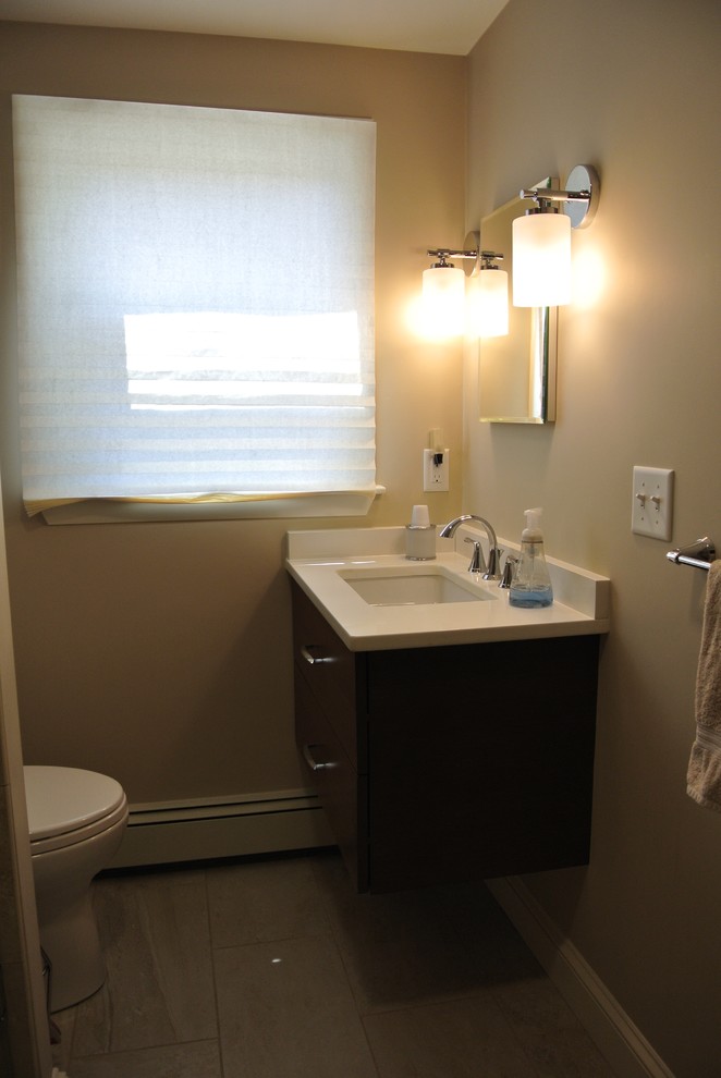 Alcove shower - transitional beige tile and porcelain tile porcelain tile and beige floor alcove shower idea in Boston with flat-panel cabinets, dark wood cabinets, a two-piece toilet, beige walls, an undermount sink, quartz countertops, a hinged shower door and white countertops