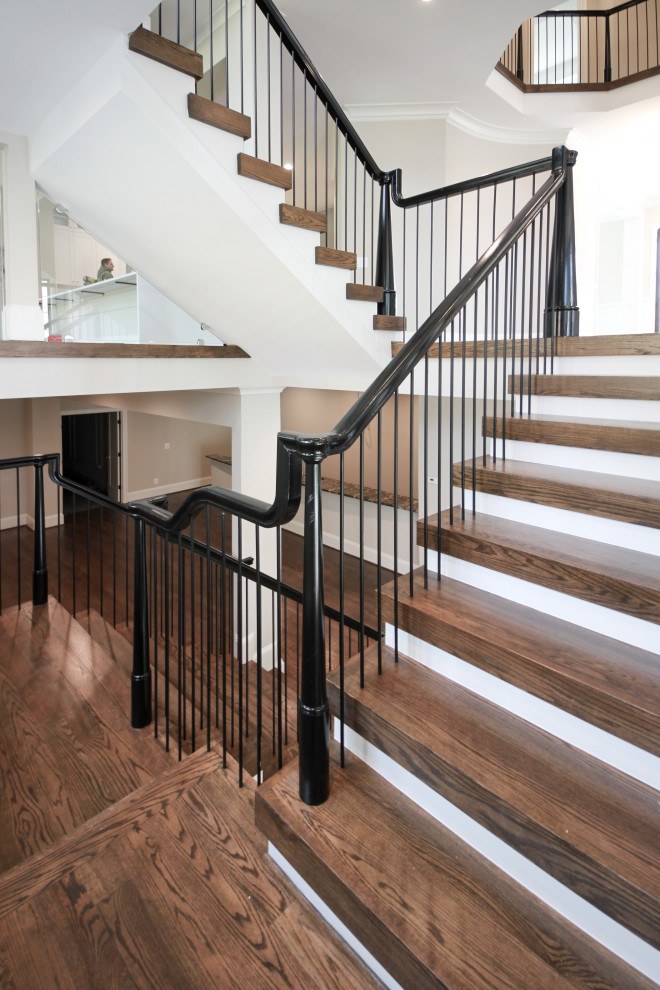 Idée de décoration pour un très grand escalier bohème en U avec des marches en bois, des contremarches en bois et un garde-corps en matériaux mixtes.