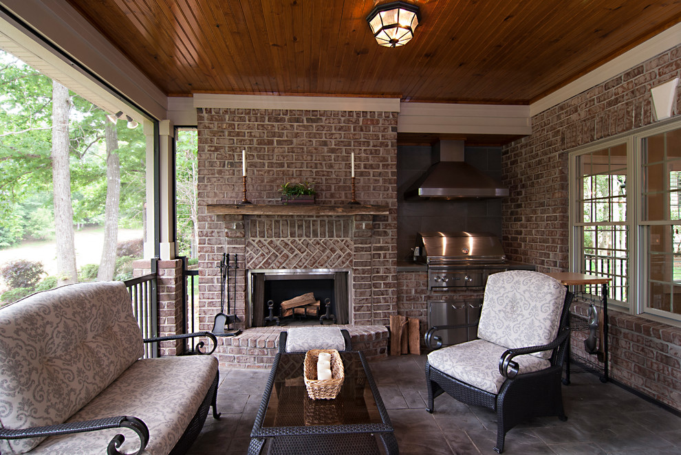Photo of a mid-sized traditional backyard verandah in Charlotte with a roof extension and natural stone pavers.