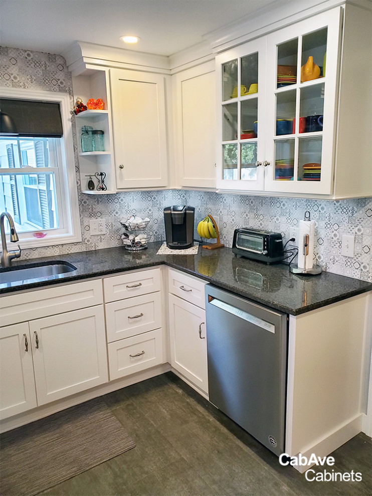 Example of a small transitional u-shaped dark wood floor and gray floor eat-in kitchen design in New York with an undermount sink, shaker cabinets, white cabinets, granite countertops, multicolored backsplash, porcelain backsplash, stainless steel appliances, no island and black countertops