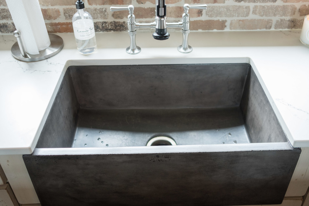 Large transitional galley dark wood floor and brown floor home design photo with a farmhouse sink, shaker cabinets, quartz countertops, brown backsplash, brick backsplash, stainless steel appliances and an island
