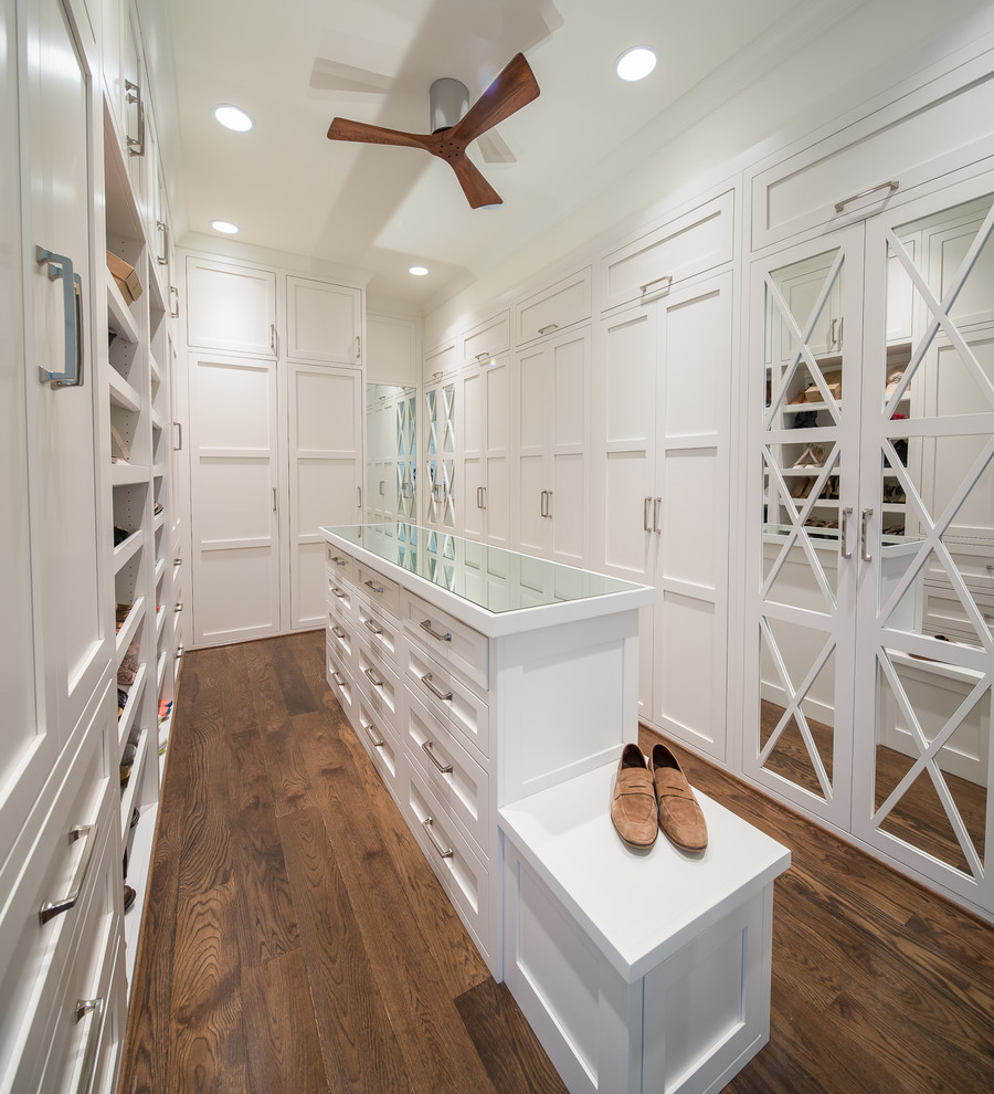 Inspiration for a transitional gender-neutral walk-in wardrobe in Atlanta with shaker cabinets, white cabinets, dark hardwood floors and brown floor.