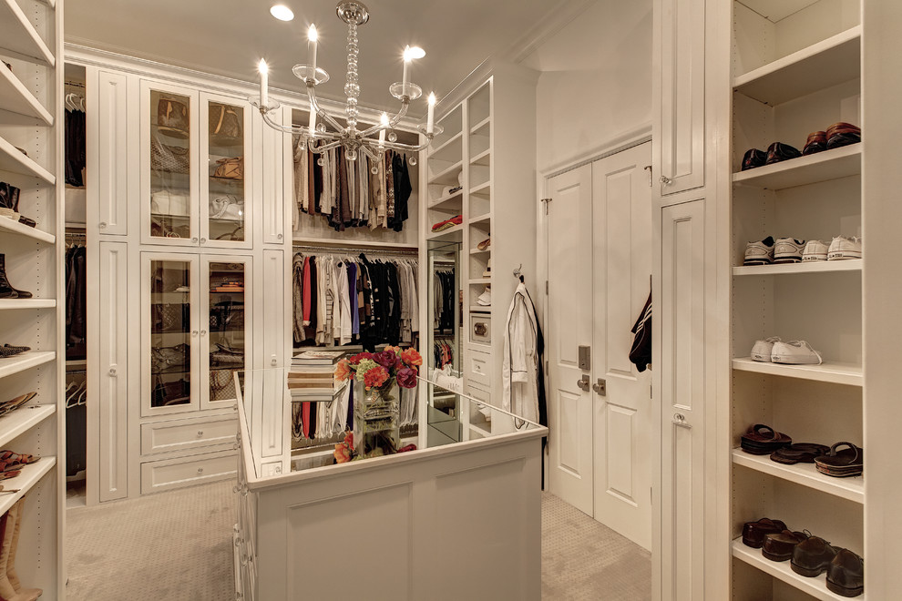 This is an example of a traditional gender-neutral storage and wardrobe in Dallas with recessed-panel cabinets, white cabinets and carpet.