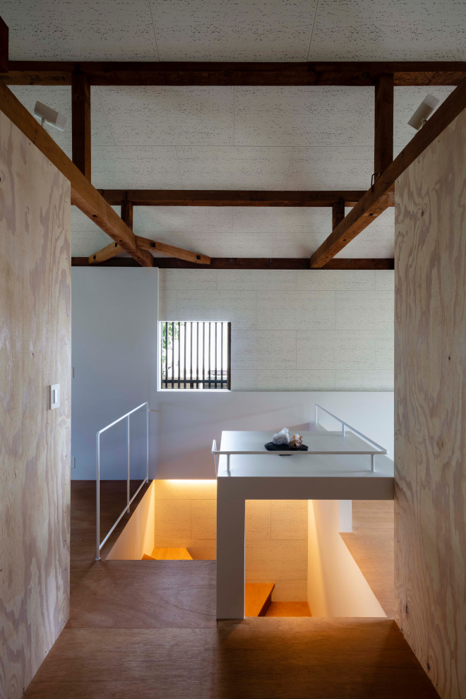 Kleine Holztreppe in U-Form mit Holz-Setzstufen, Stahlgeländer und Wandpaneelen in Kobe