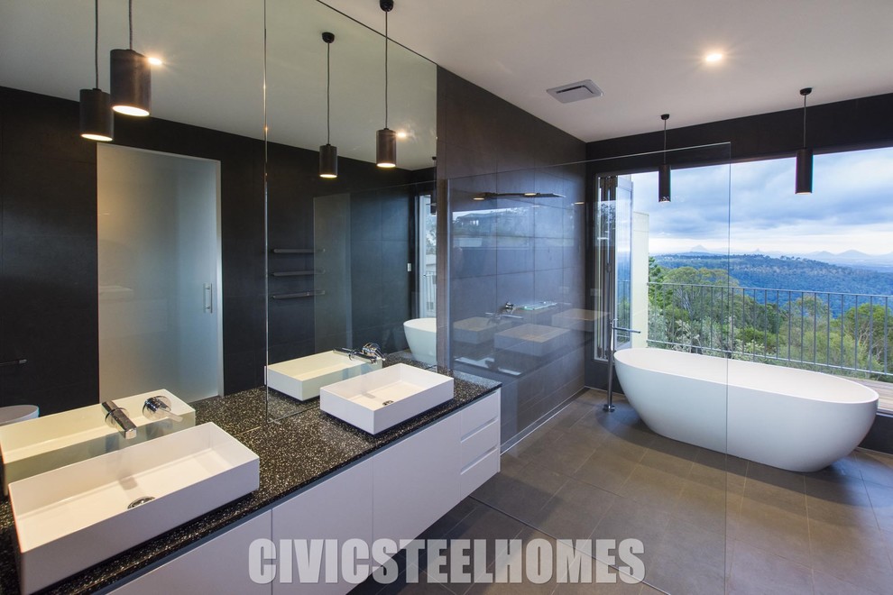 Design ideas for a mid-sized master bathroom in Brisbane with raised-panel cabinets, white cabinets, a freestanding tub, an open shower, a wall-mount toilet, gray tile, porcelain tile, grey walls, porcelain floors, a trough sink and engineered quartz benchtops.