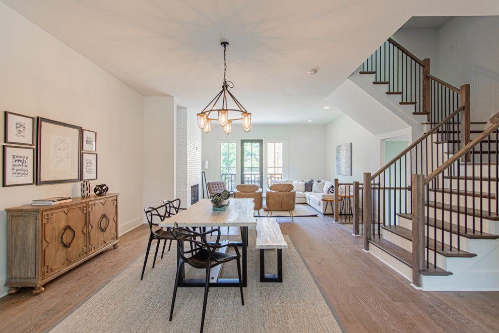 Photo of a large transitional open plan dining in Atlanta with white walls, light hardwood floors, a standard fireplace, a brick fireplace surround and beige floor.