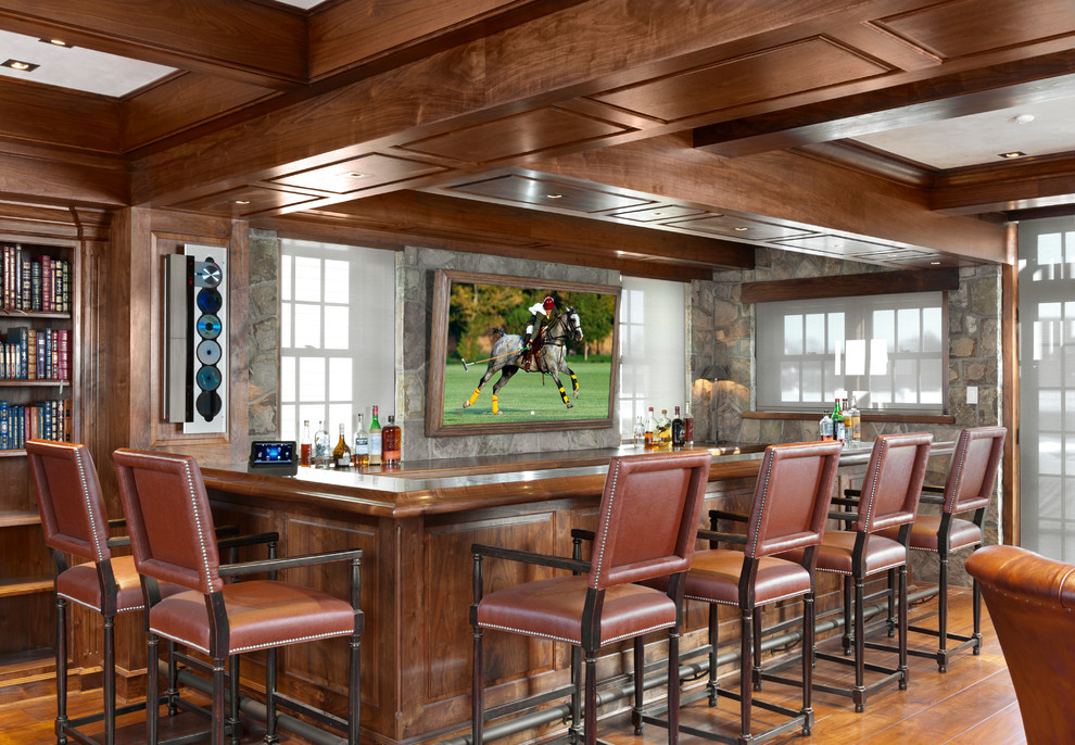 Inspiration for a large traditional u-shaped seated home bar in New York with wood benchtops, medium hardwood floors, brown floor and brown benchtop.