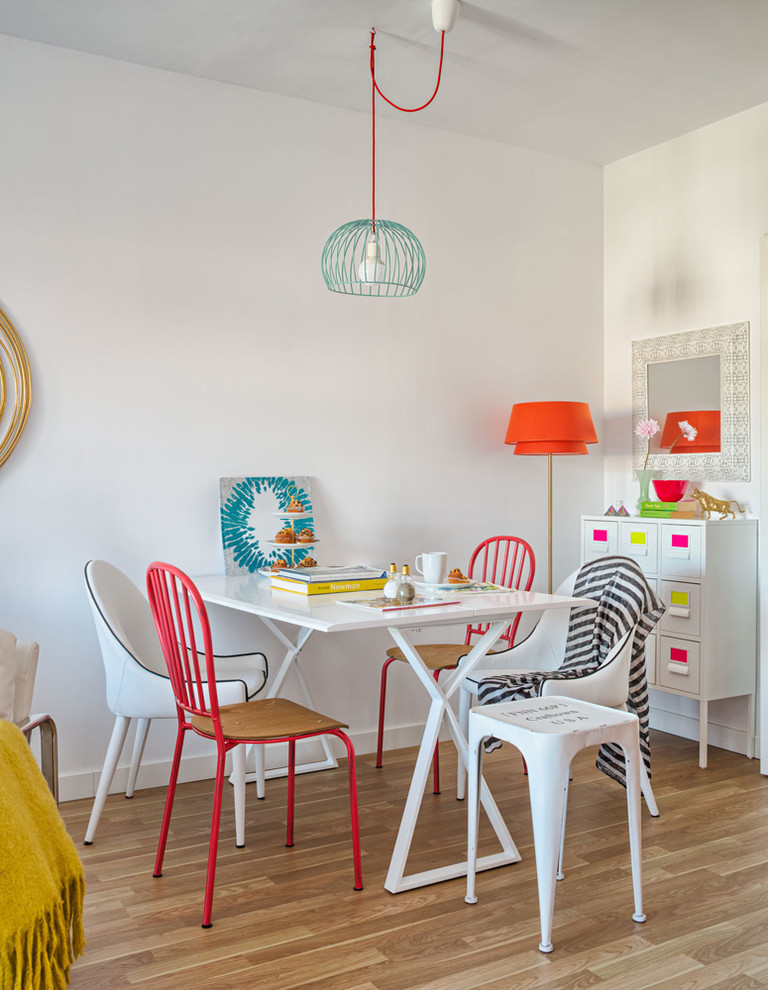 Small eclectic open plan dining in Malaga with white walls, light hardwood floors and no fireplace.