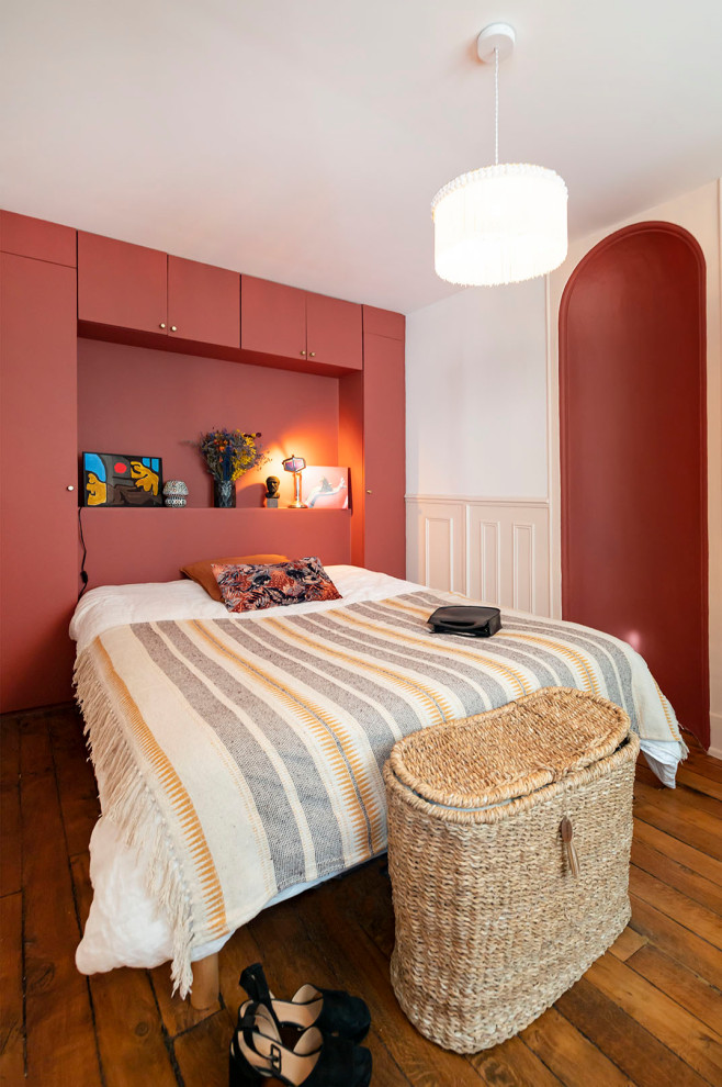 This is an example of a small classic master bedroom in Paris with red walls.