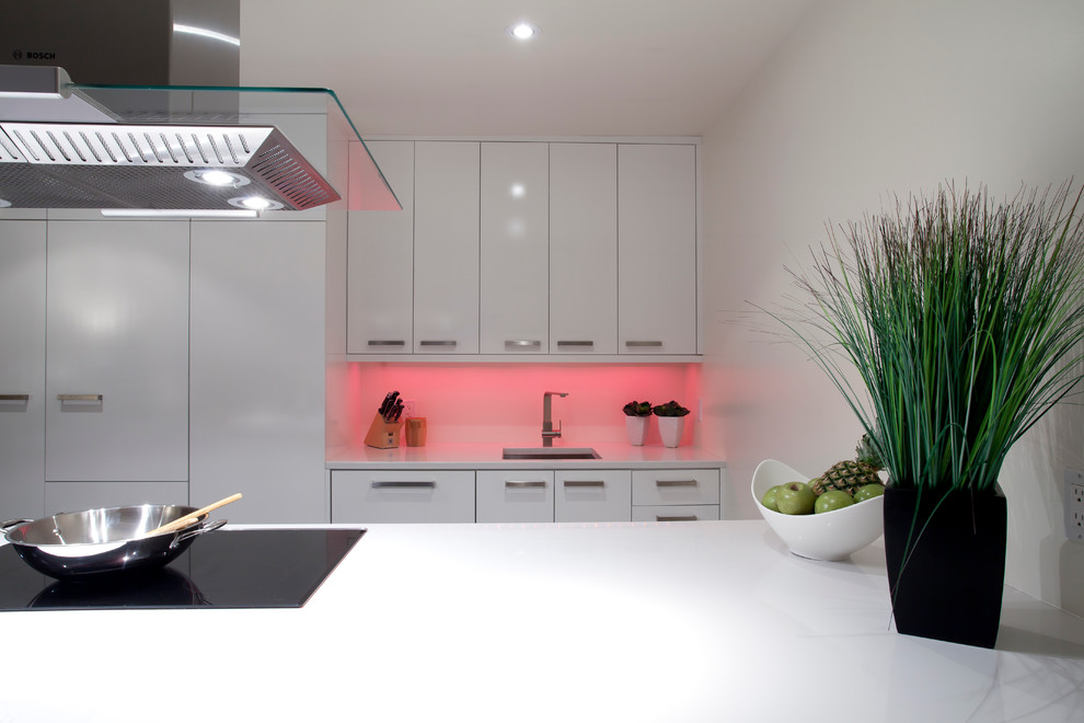 Photo of a mid-sized contemporary galley eat-in kitchen in Other with an undermount sink, flat-panel cabinets, white cabinets, white splashback, panelled appliances and a peninsula.
