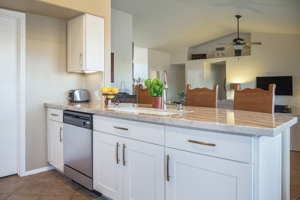 Open concept kitchen - transitional galley ceramic tile open concept kitchen idea in Phoenix with an undermount sink, recessed-panel cabinets, white cabinets, quartz countertops, white backsplash, ceramic backsplash, stainless steel appliances and an island