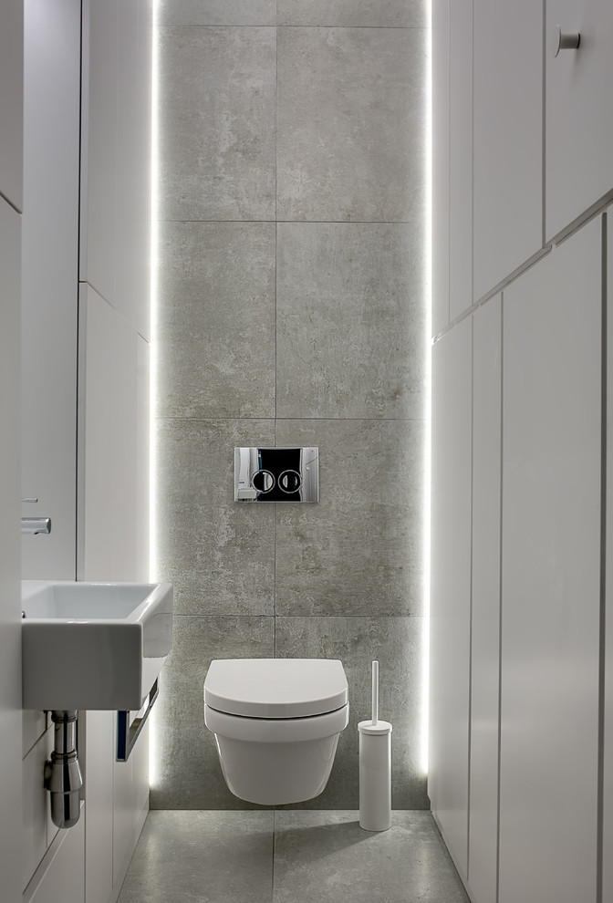 Industrial powder room in Moscow with a wall-mount toilet, a wall-mount sink and grey floor.