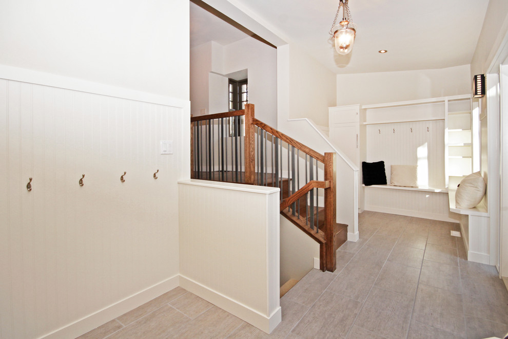 Mudroom - small transitional mudroom idea in Calgary with white walls and a black front door