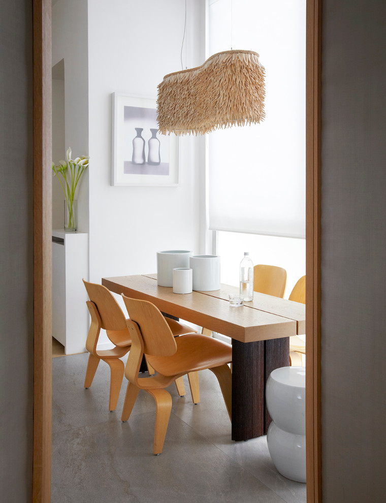 Photo of a mid-sized scandinavian separate dining room in Paris with white walls, concrete floors and no fireplace.