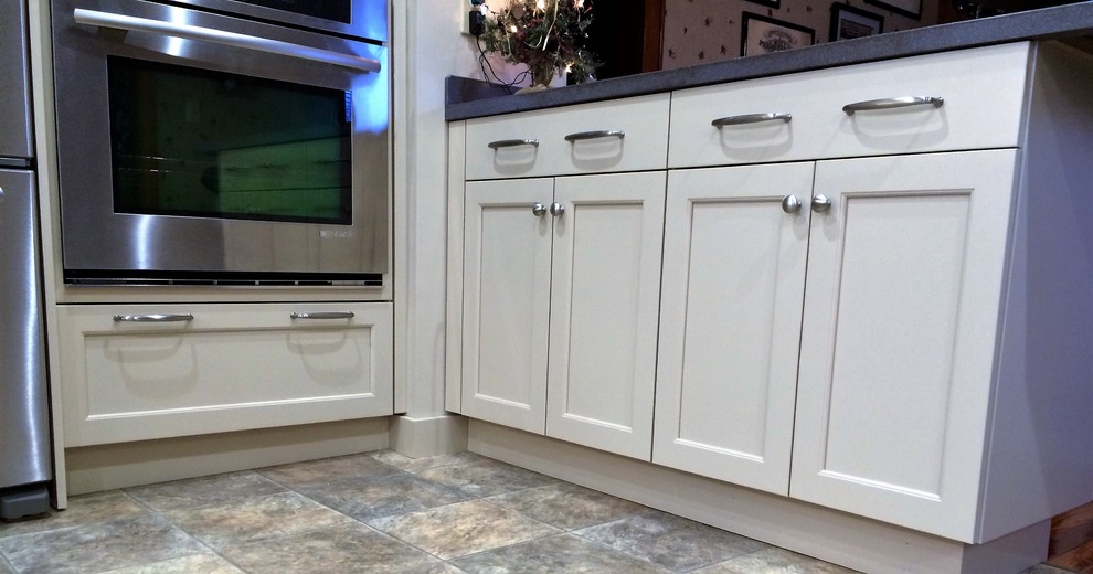 Eat-in kitchen - mid-sized transitional u-shaped linoleum floor eat-in kitchen idea with an integrated sink, recessed-panel cabinets, white cabinets, solid surface countertops, white backsplash, ceramic backsplash, stainless steel appliances and a peninsula