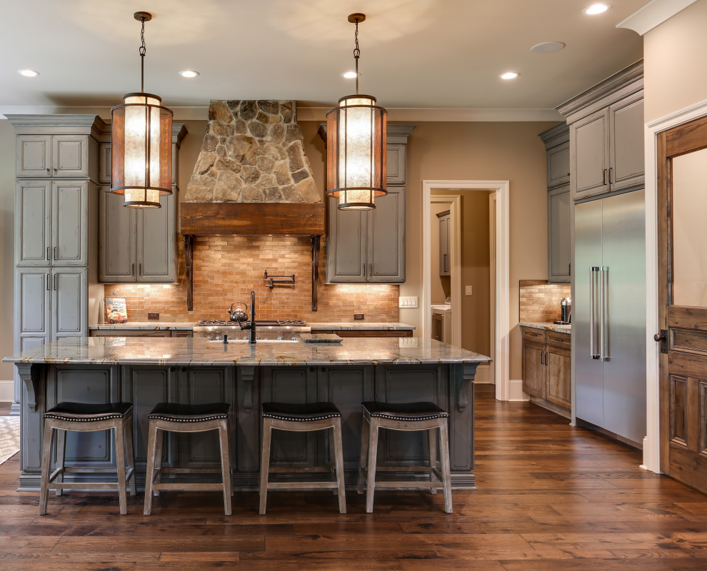 Photo of a country l-shaped open plan kitchen in Raleigh with a farmhouse sink, dark wood cabinets, brown splashback, stainless steel appliances, dark hardwood floors, with island, brown floor, grey benchtop and raised-panel cabinets.