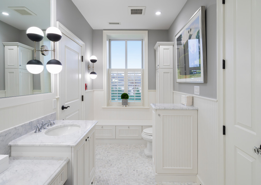 Пример оригинального дизайна: главная ванная комната в стиле неоклассика (современная классика) с фасадами с декоративным кантом, белыми фасадами, керамогранитной плиткой, серыми стенами, мраморным полом, консольной раковиной, мраморной столешницей, серым полом, душем с распашными дверями, белой столешницей, тумбой под две раковины, напольной тумбой и панелями на части стены