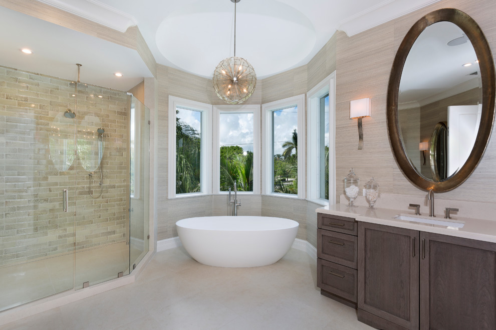 Design ideas for a large beach style master bathroom in Other with dark wood cabinets, a freestanding tub, an alcove shower, beige tile, subway tile, beige walls, ceramic floors, an undermount sink, solid surface benchtops, beige floor, a hinged shower door, beige benchtops and shaker cabinets.