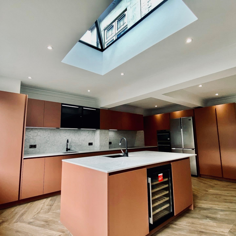 Inspiration for a mid-sized modern l-shaped eat-in kitchen in Essex with an integrated sink, flat-panel cabinets, red cabinets, granite benchtops, grey splashback, granite splashback, panelled appliances, vinyl floors, with island, brown floor, grey benchtop and vaulted.