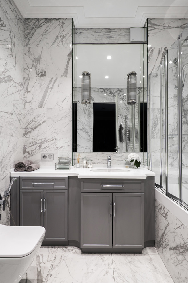 Inspiration for a mid-sized transitional master bathroom in Moscow with recessed-panel cabinets, grey cabinets, an alcove tub, a shower/bathtub combo, an undermount sink, gray tile, grey walls, grey floor and a sliding shower screen.