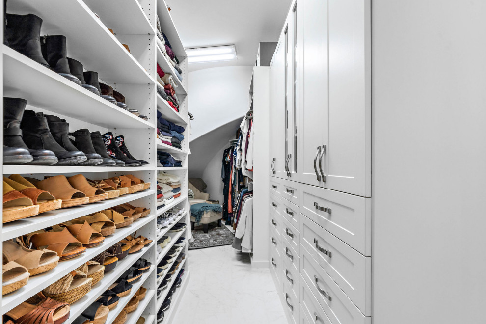 Mid-sized contemporary gender-neutral walk-in wardrobe in Houston with shaker cabinets, white cabinets, porcelain floors, white floor and recessed.